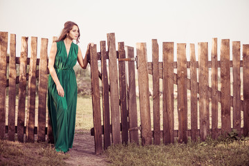 woman in green at vintage fence
