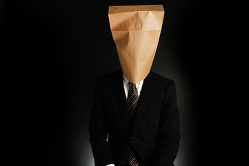 紙袋で顔を隠したスーツのビジネスマンのポートレート