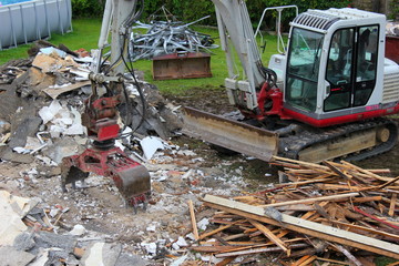 Bagger bei den Abbrucharbeiten an einem alten Haus