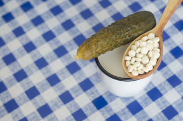 Salted cucumber, mug with milk and pills