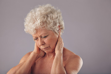 Senior woman in discomfort with sore neck