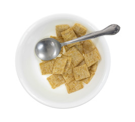 Leftover whole wheat cereal in bowl with spoon