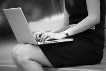 Naklejka premium Beautiful young woman using laptop in park
