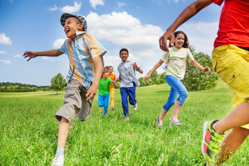 Kids in motion of running on green field