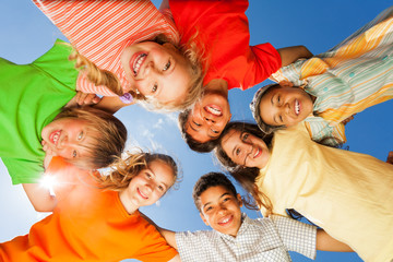 Happy children close in circle on sky background