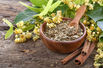 linden tea in a wooden bowl with cinnamon sticks