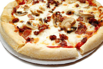 Close-Up of a Bacon and Mushroom Pizza on Cardboard