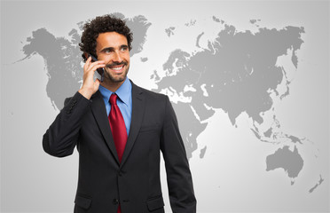 Man talking on the phone in front of a world map