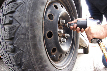 Auto mechanic changing car wheel