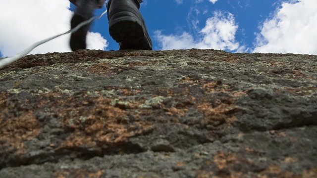 Man Climbs Up on top of the Rock 