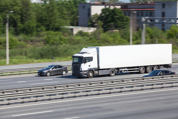 Container chassis truck driving on the highway near cars