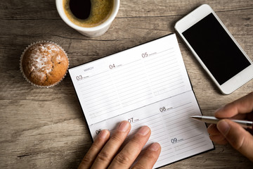 male hand writing at planning notebook