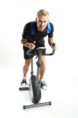 Rower treningowy - mężczyzna na treningu - obrazy, fototapety, plakaty