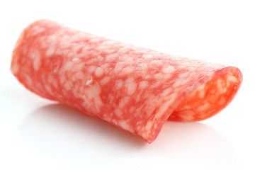 Thin slices of salami rolled into shape on white background.