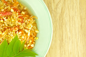 Green papaya salad or som tam with leaves of gooseberry