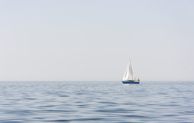 Obraz premium Blue sail boat at sea or ocean
