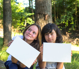 Banner: Two young  girl holding clean white sheet paper.