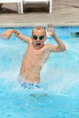 Plakat Young boy kid jumping in the pool on vacation