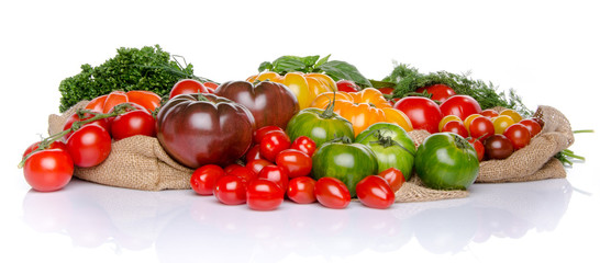 Composition of different varieties of tomatoes and herbs on a bu