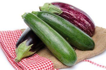 Eggplants and zucchini on a burlap bag