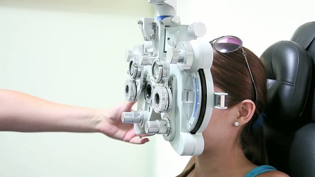 Optometrist doing sight testing for patient.