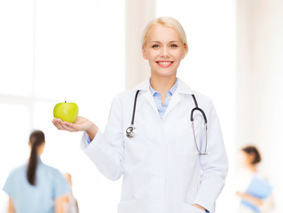 smiling female doctor with green apple