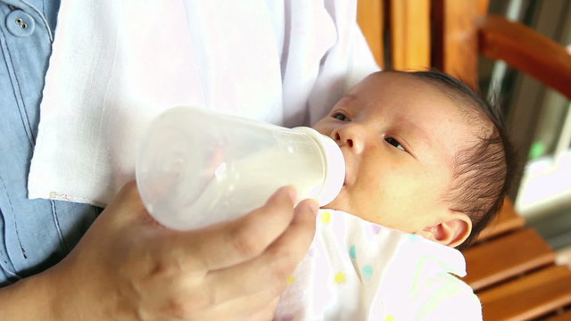 Closeup feeding new born baby with baby bottle
