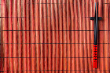 Two chopsticks on sushi mat background