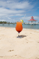 Cold cocktail in sand on beach