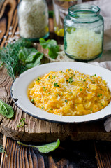 Carrot risotto in the plate on wooden table