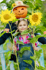 Scarecrow and happy girl  in the garden