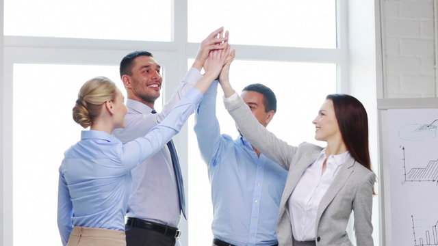 business team doing high five gesture in office