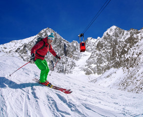 Skier against blue sky in high mountains