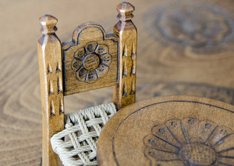 Mini wooden hand made chair on carved table