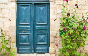 Fototapeta na wymiar blue front door with purple flowers