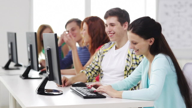 smiling students working with computers at school