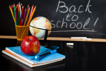 School supplies against blackboard.
