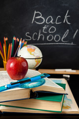 School supplies against blackboard.