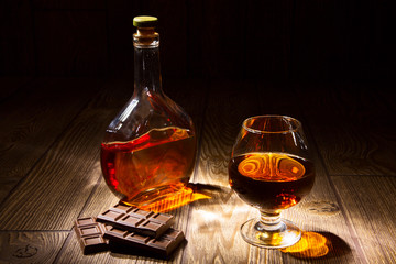 Bottle and a glass of brandy with chocolate