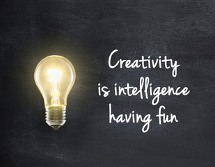 Light bulb lamp on blackboard background with creativity quote