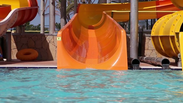 Grandpa with grandson sliding on water slide in water park