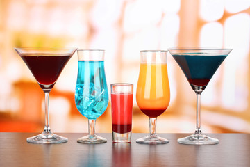 Several glasses of different drinks on bright background