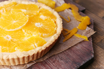 Homemade orange tart on wooden background