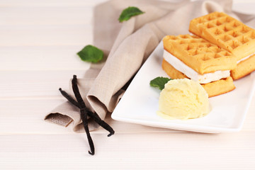 Tasty belgian waffles with ice cream on wooden table