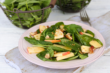 Green salad with apples, walnuts and cheese on wooden