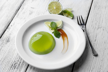 Green jelly with mint leaves on wooden background