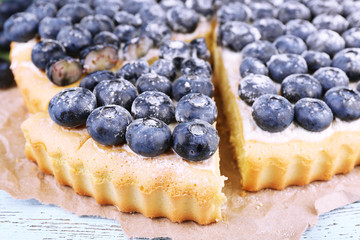 Tasty homemade pie with blueberries on wooden table