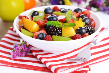 Delicious fruits salad in plate on table close-up