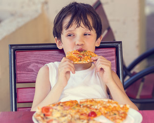 boy eating pizza in a restaurant