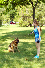 Beautiful young girl with dog in park
